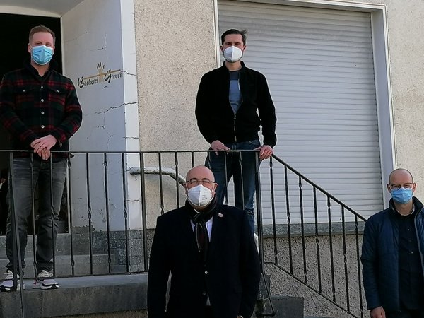 Bürgermeister, Wirtschaftsförderer und Geschäftsführer auf der Treppe vor den Geschäftsräumen