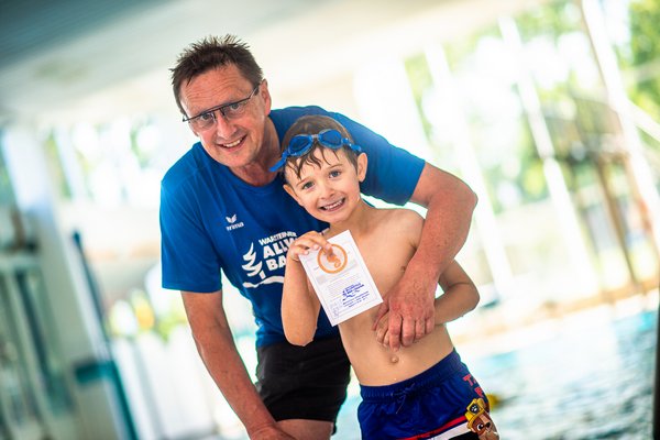 Schwimmmeister und Kind zeigen das Seepferdchenabzeichen, Foto: Flye GbR