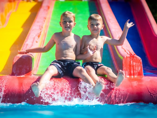Kinder auf die Rutsche im Allwetterbad