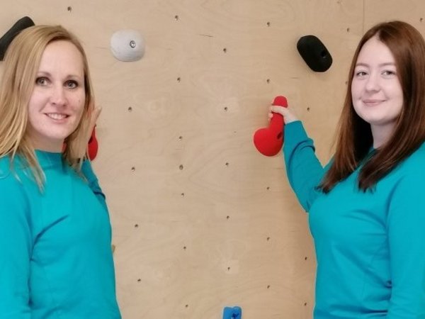 Zwei Ergotherapeutinnen vor einer Kletterwand