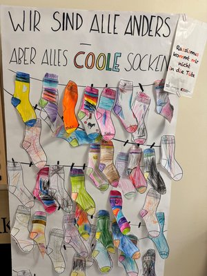 Bunte Papiersocken hängen an einer Pin-Wand