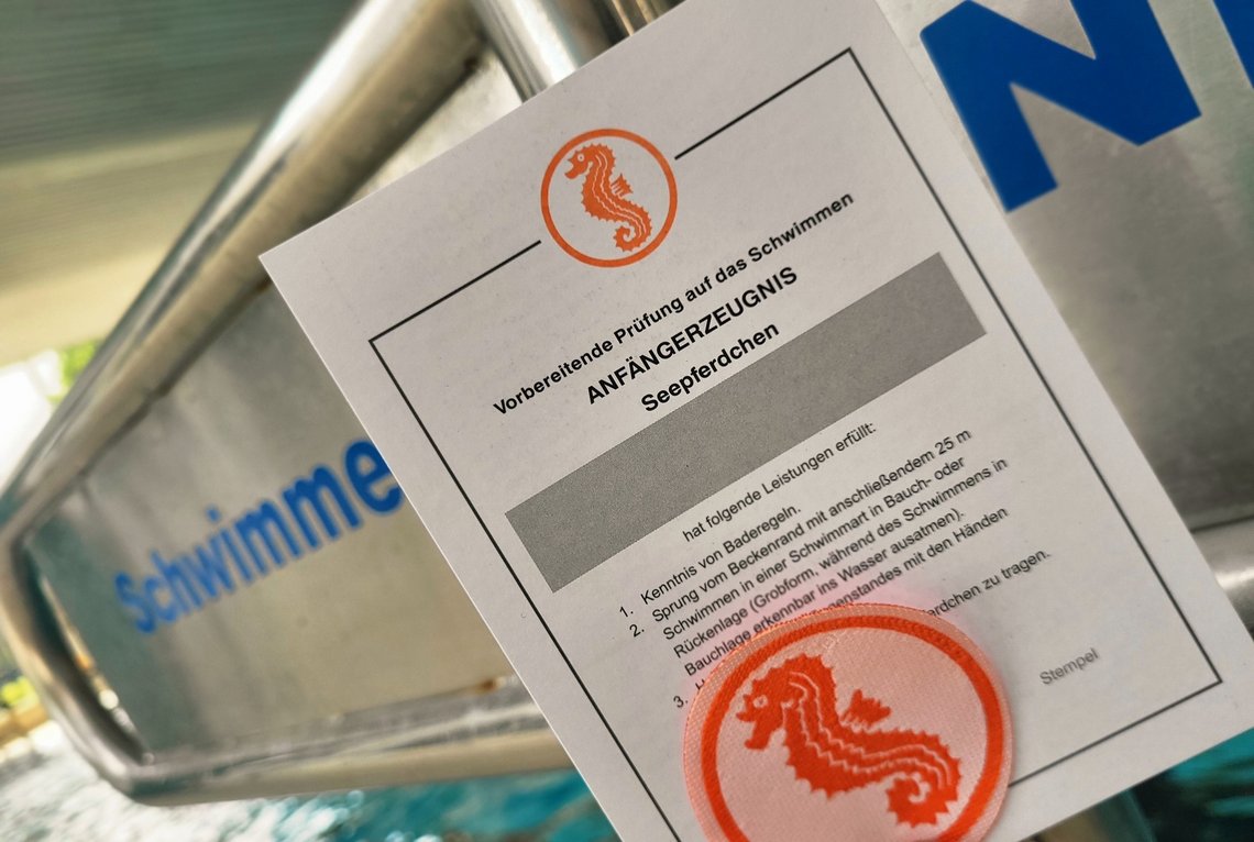 Seepferdchenaufnäher und das Anfängerzeugnis am "Schwimmer/Nichtschwimmer" -Schild
