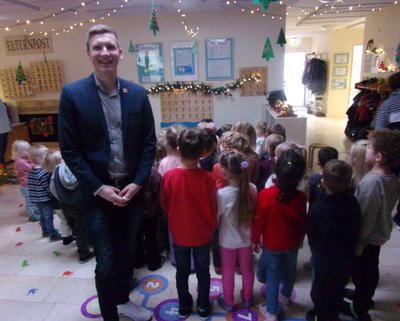 Der Bürgermeister steht vor einer Gruppe Kinder