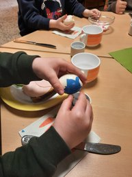 Fokus auf Kinderhände, die ein bemaltes Ei pellen