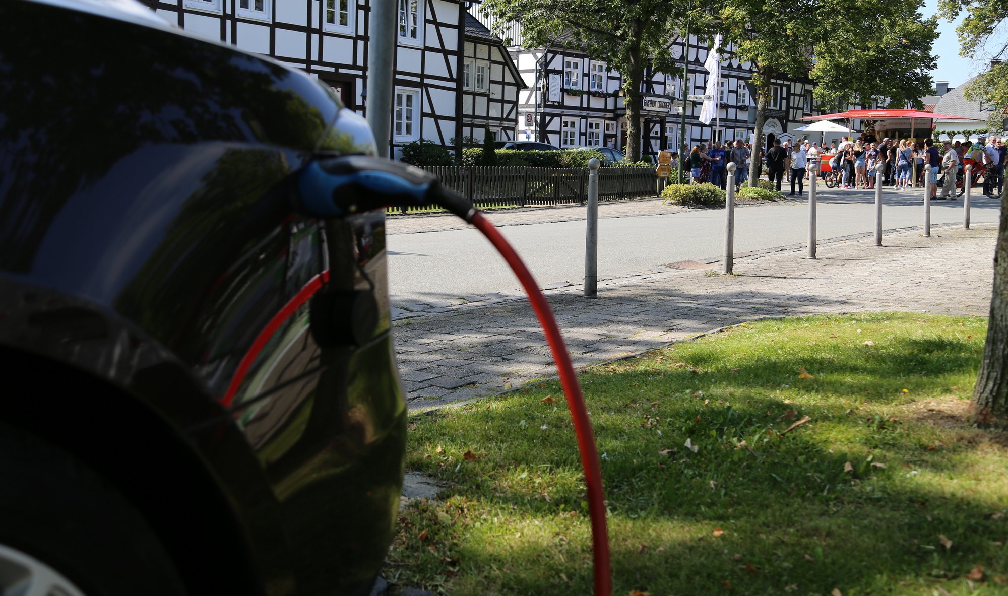 E-Auto lädt, im Hintergrund der Gasthof Cramer in Hirschberg, Foto: Uwe Nutsch