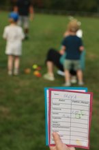 Bild einer Stempelkarte für "Hanna", im Hintergrund sieht man mehrere Kinder auf einer Wiese spielen