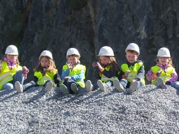 Kinder sitzen auf einem Kiesberg, Foto: Familienzentrum Hirschberg