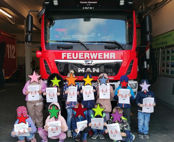 Foto der Kinder vor einem Feuerwehrfahrzeug