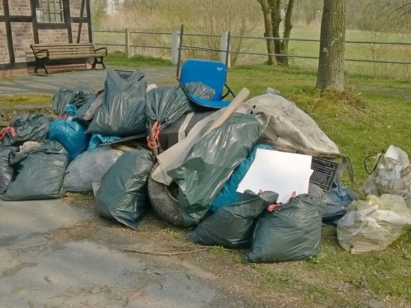 Ein Autoreifen und Sperrmüll in einem Stapel aus gefüllten blauen Säcken