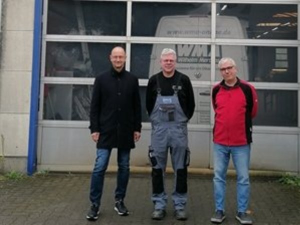 Gruppenfoto des Wirtschaftsförderers mit den Geschäftsführern vor dem Firmengebäude