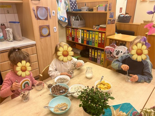 Kinder am Esstisch bereiten Müsli zu