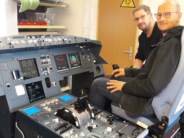 Geschäftsführer und Wirtschaftsförderer an einem Flugsimulator