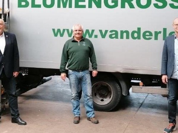 Bürgermeister, Geschäftsführer und Wirtschaftsförderer vor einem Firmen-LKW