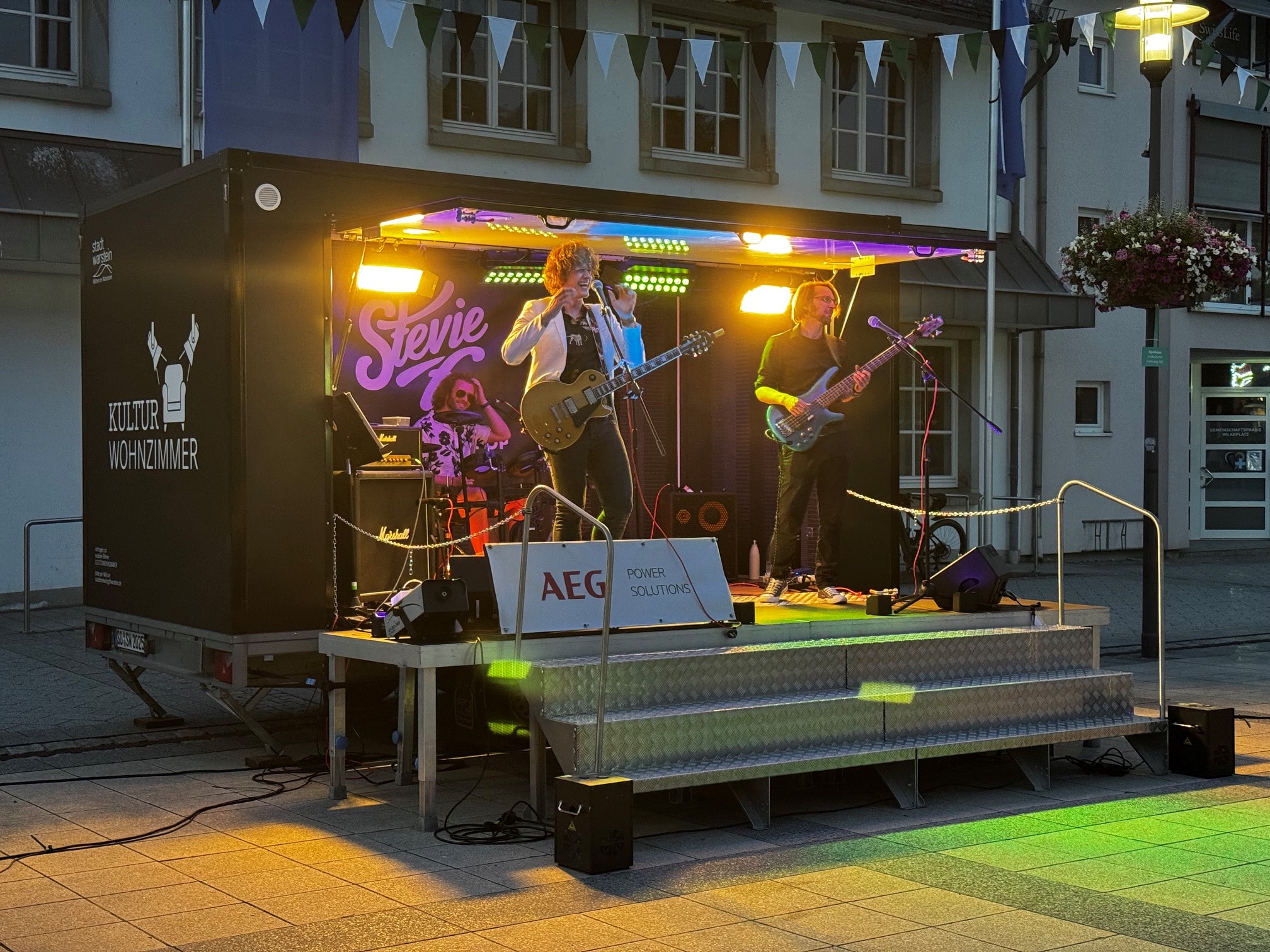 Zweite Runde für „Wilkeplatz Live“: Der sommerliche Open-Air-Abend mit der Band Stevie X Classic Rock lockte zahlreiche Besucherinnen und Besucher auf den Wilkeplatz in Belecke und sorgte für beste Stimmung sowie ein geselliges Beisammensein. Zweite Runde für „Wilkeplatz Live“: Der sommerliche Open-Air-Abend mit der Band Stevie X Classic Rock lockte zahlreiche Besucherinnen und Besucher auf den Wilkeplatz in Belecke und sorgte für beste Stimmung sowie ein geselliges Beisammensein.